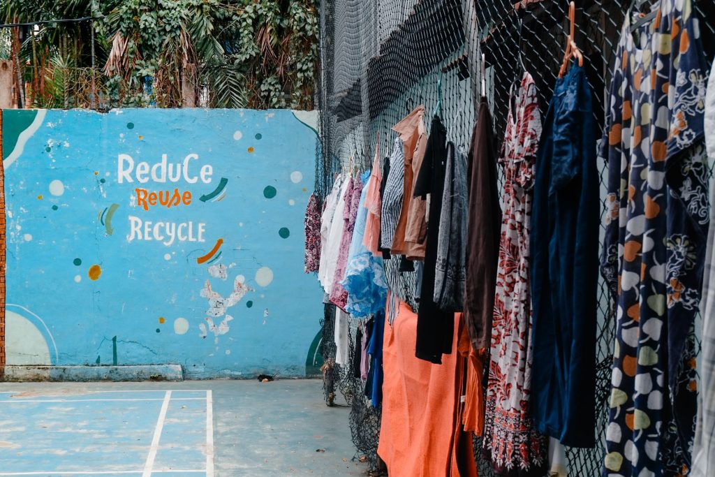 colorful clothes hanging by reduce reuse recycle mural